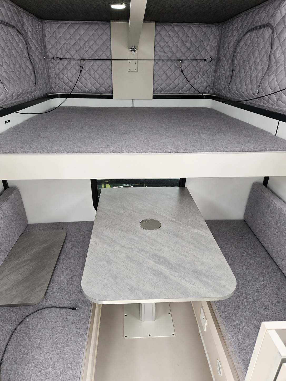Slide On Camper interior with bed and dining area