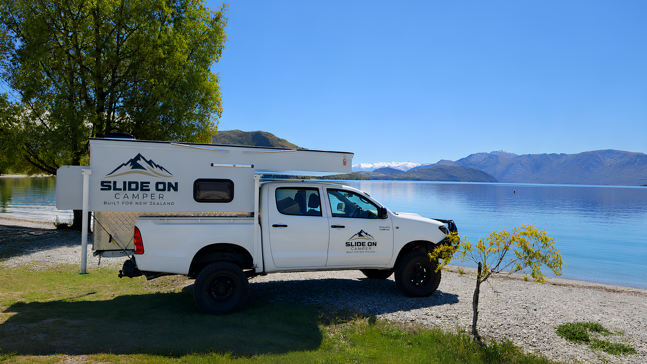 Slide On Camper on a ute beside a New Zealand lake